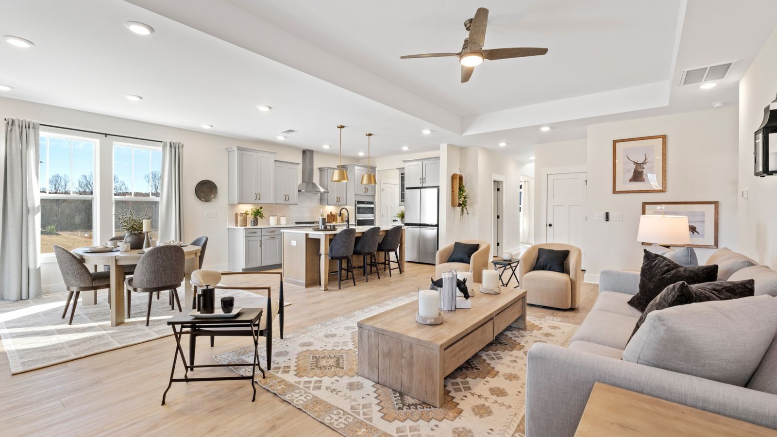 Open concept living spaces with hardwood flooring, elevated ceilings, and ceiling fan at Fox Hollow by DRB Homes