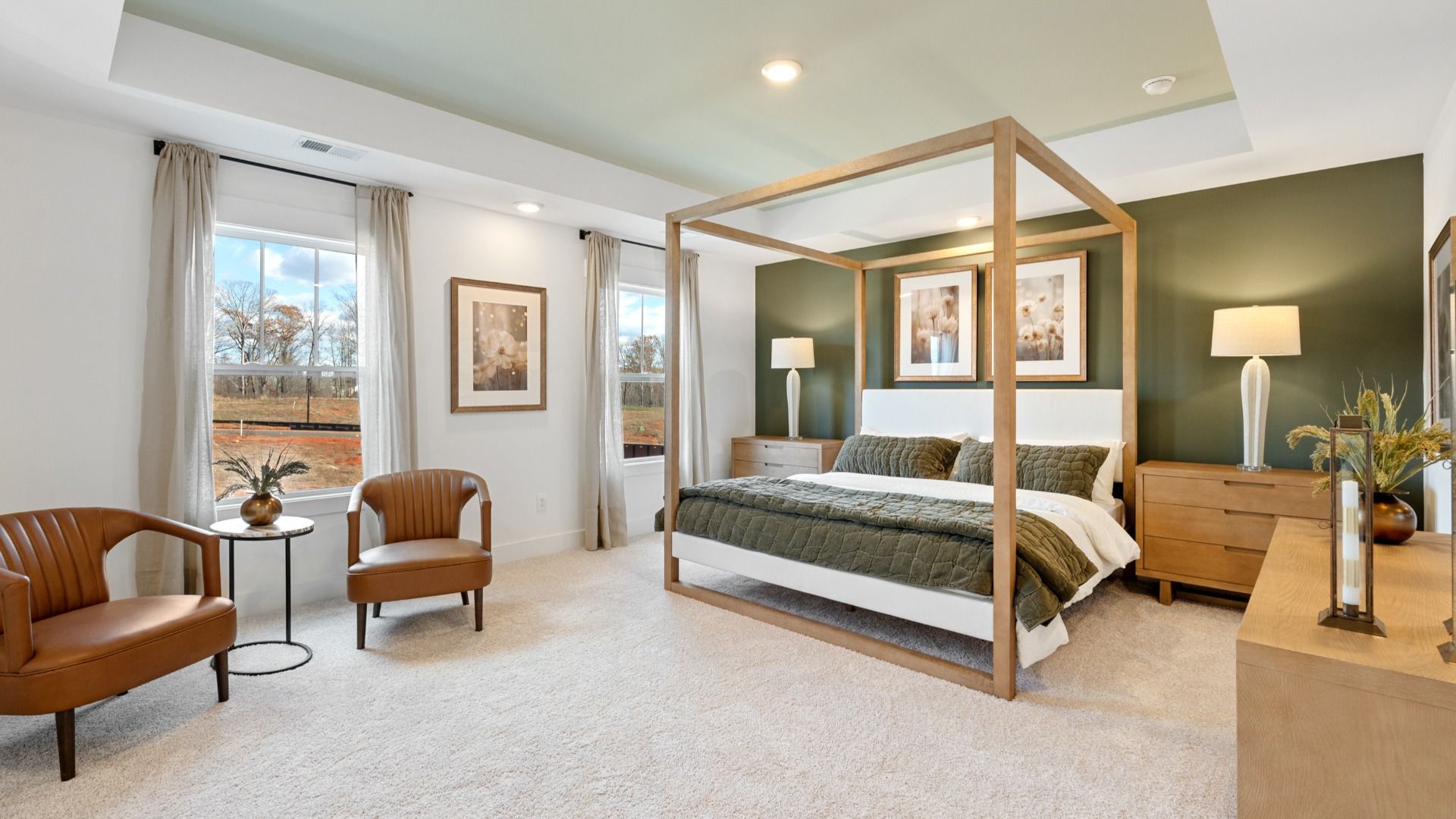 Inviting primary suite with plush carpet, vaulted ceilings, large windows, and green accents at Fox Hollow by DRB Homes