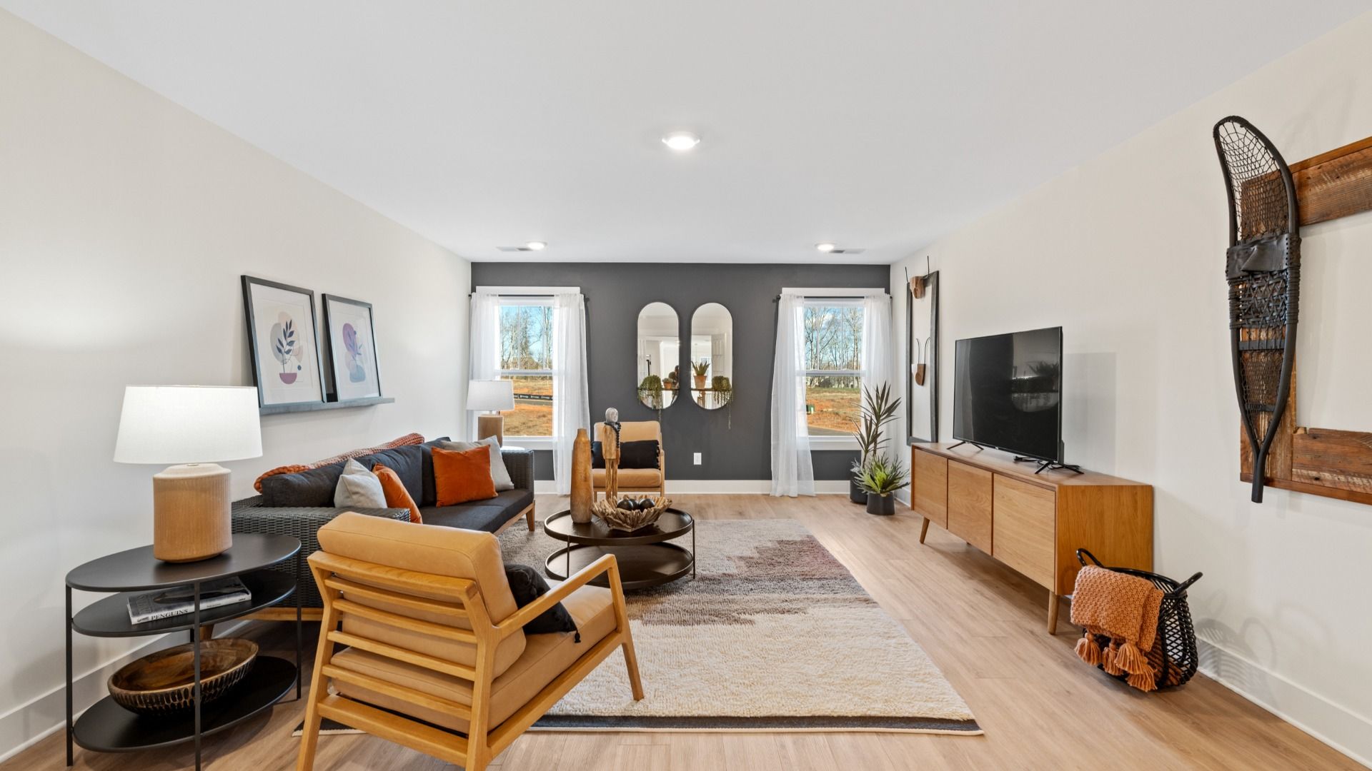 Modern bonus room with elevated ceilings, hardwood flooring, and large windows at Fox Hollow in Spartanburg, SC