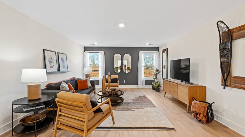 Modern bonus room with elevated ceilings, hardwood flooring, and large windows at Fox Hollow in Spartanburg, SC