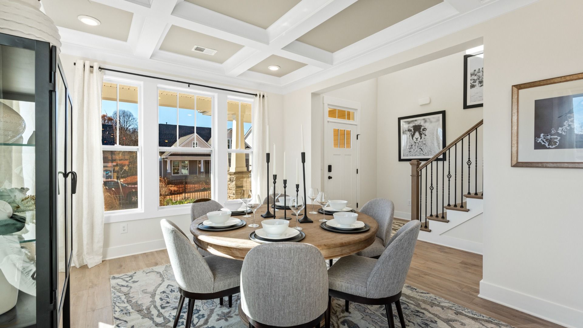Large dining room with luxury coffered ceiling, bay windows, and hardwood flooring at Fox Hollow by DRB Homes in Spartanburg
