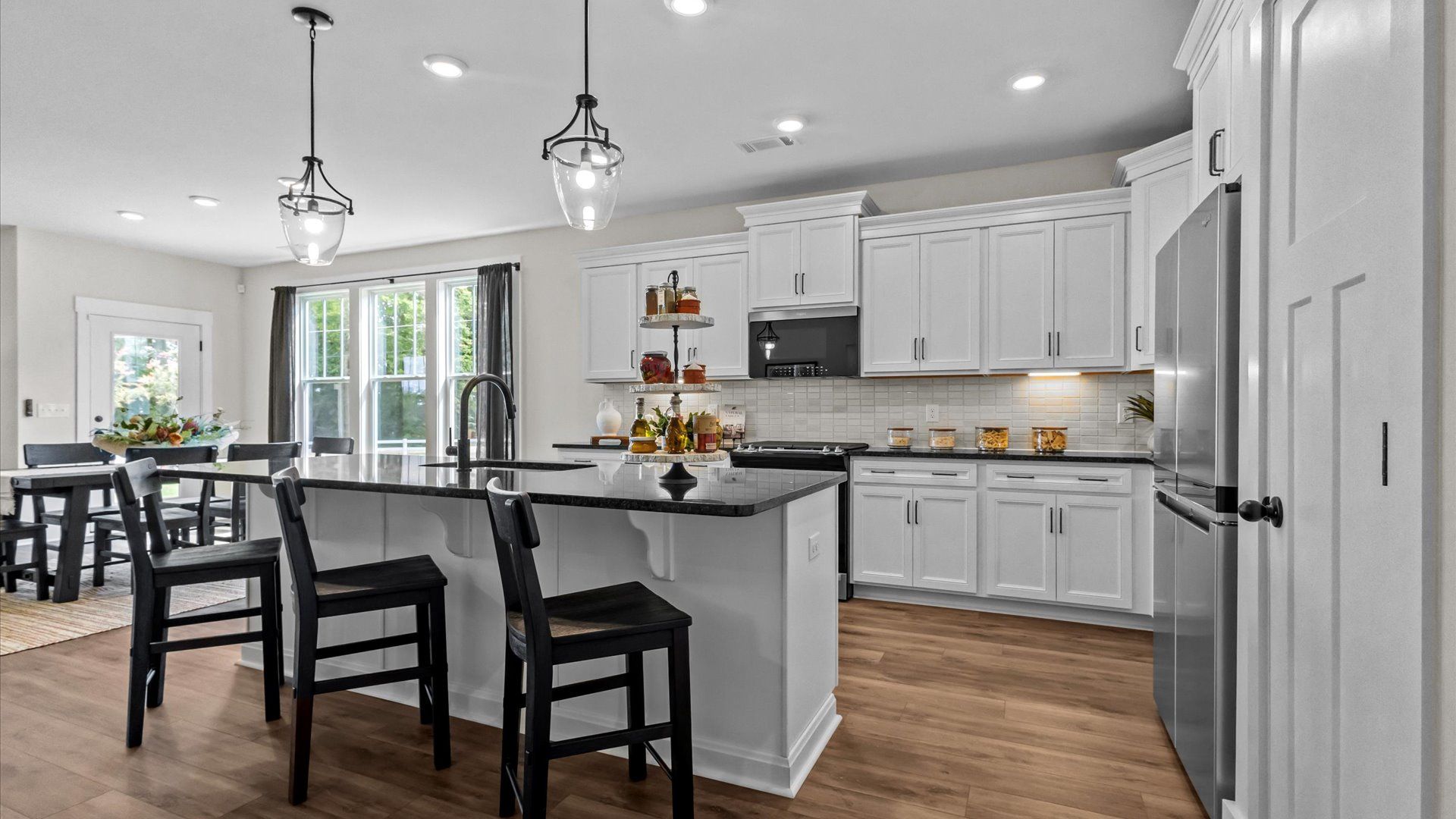 Vibrant and open kitchen centered around a 9-foot island with elegant pendant lighting above