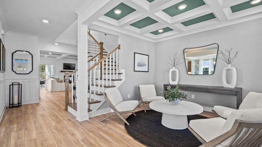 First-class living area featuring a coffered ceiling and thoughtful architectural detail
