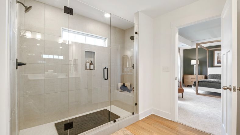 Luxury primary bathroom with tiled walk-in Roman shower at Mulberry Estates by DRB Homes in Simpsonville, South Carolina
