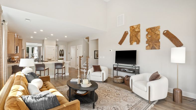 Large, open concept family room with elevated two-story ceilings and hardwood floors at Pleasant Falls in Moore, SC