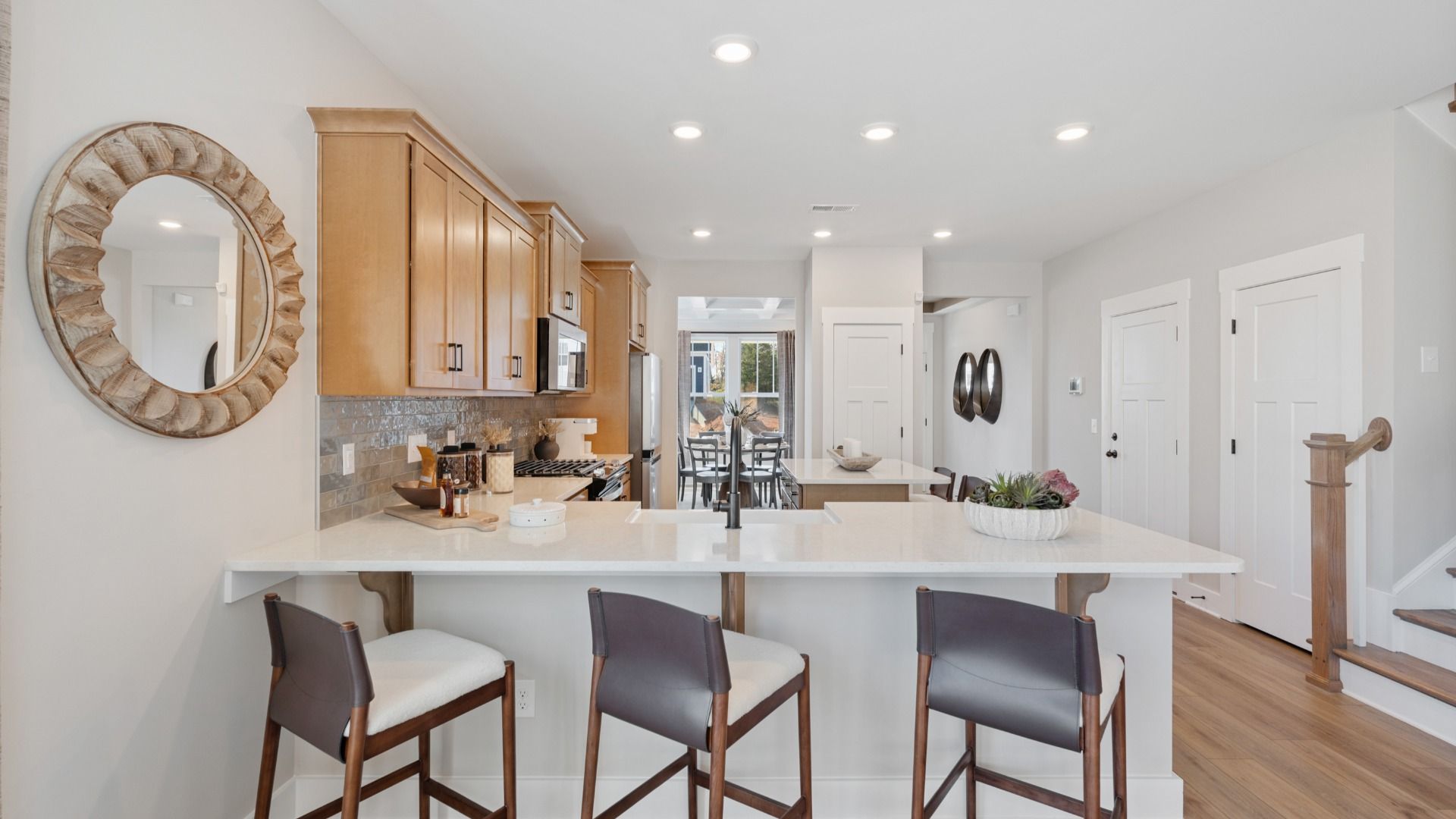Open concept kitchen with warm toned cabinetry, and large island with room for counter stools at Pleasant Falls in Moore, SC