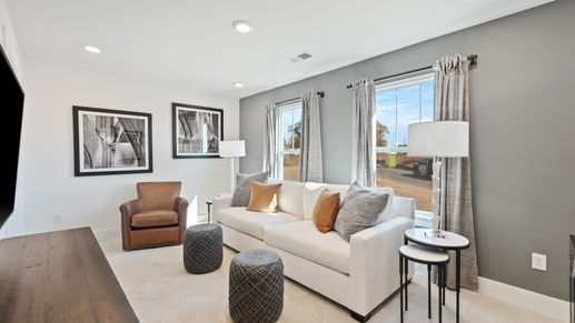 Carpeted secondary bedroom with modern accent wall, tall ceilings, and boasting windows at Pleasant Falls by DRB Homes