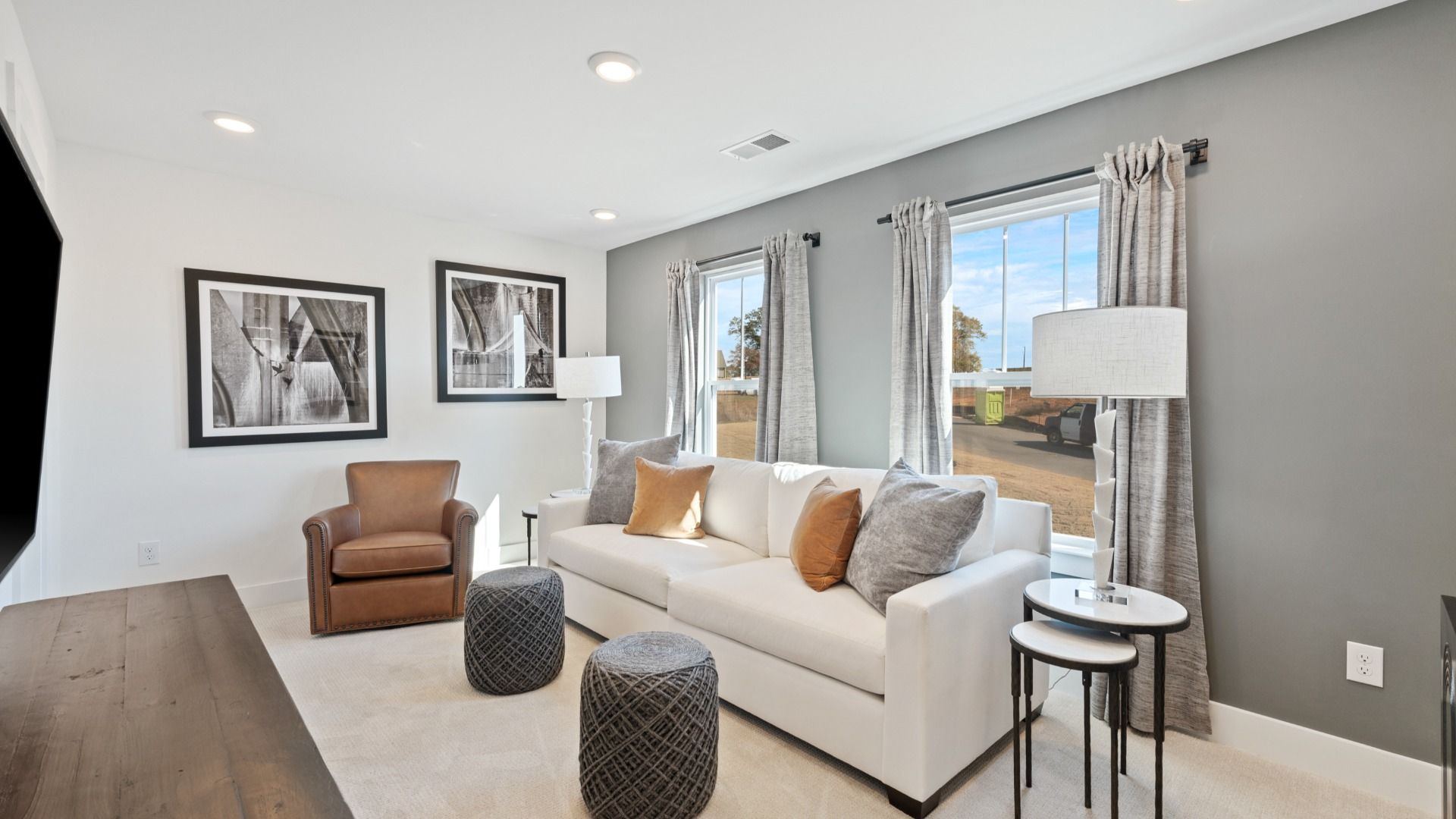 Carpeted secondary bedroom with modern accent wall, tall ceilings, and boasting windows at Pleasant Falls by DRB Homes