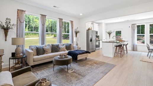 Cozy, inviting family room with elevated ceilings and large windows in two story townhome at Tyger Ridge in Spartanburg, SC