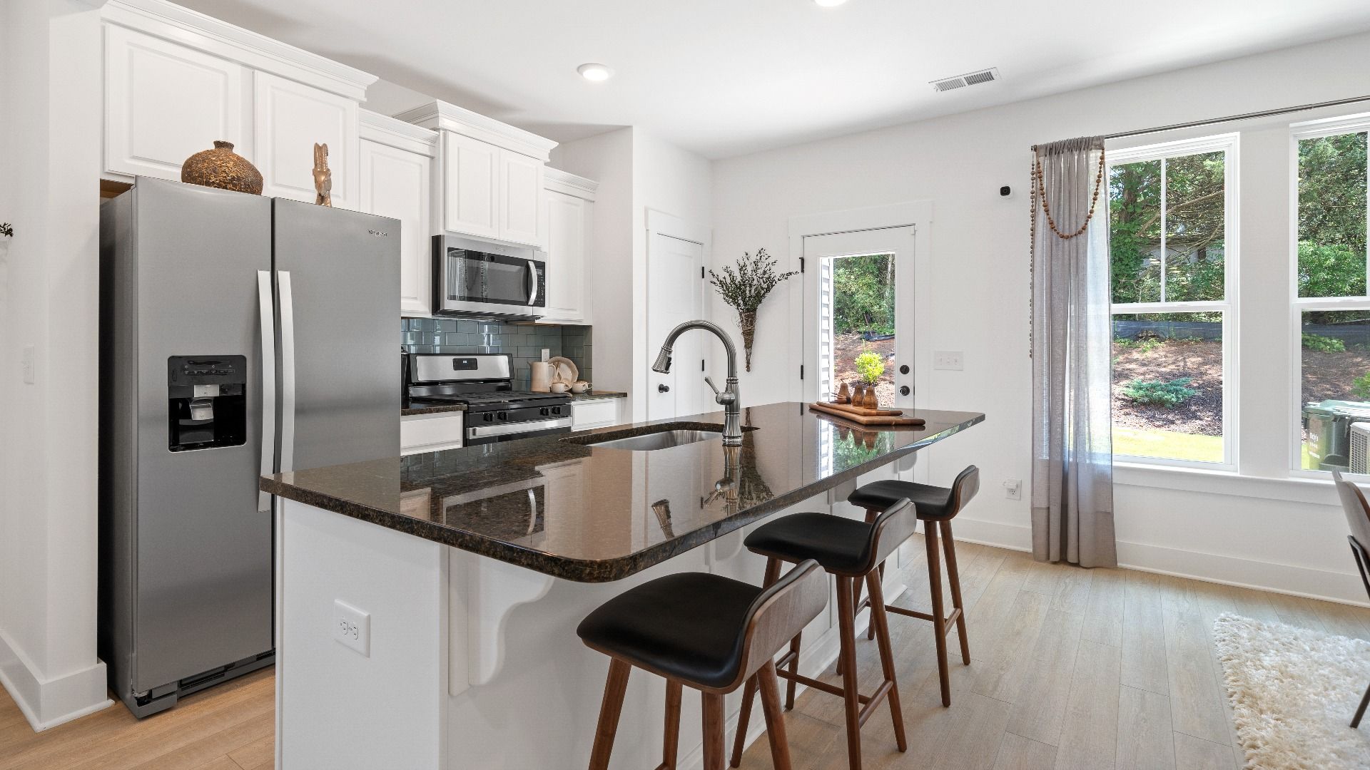 New two story townhome at Tyger Ridge in Spartanburg, SC with modern farmhouse kitchen with large island by DRB Homes