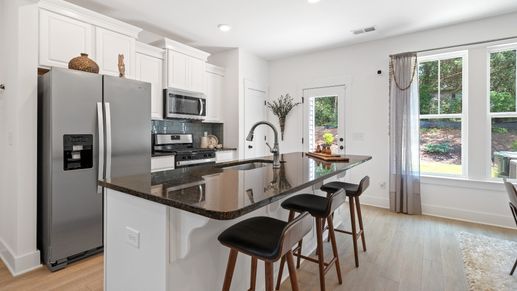 New two story townhome at Tyger Ridge in Spartanburg, SC with modern farmhouse kitchen with large island by DRB Homes