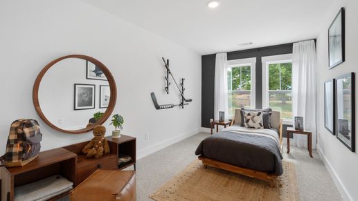Carpeted secondary bedroom with large windows at Tyger Ridge by DRB Homes in Spartanburg, SC