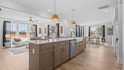 Highly skilled craftsmanship shines in this modern kitchen with pendant lighting and a central island focal point
