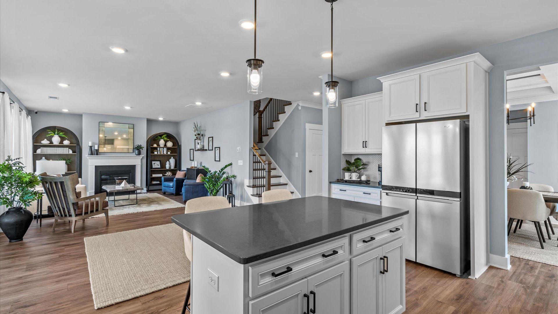 Spacious, bright kitchen with white cabinetry and modern pendant lighting at Woodglen by DRB Homes in Piedmont, SC