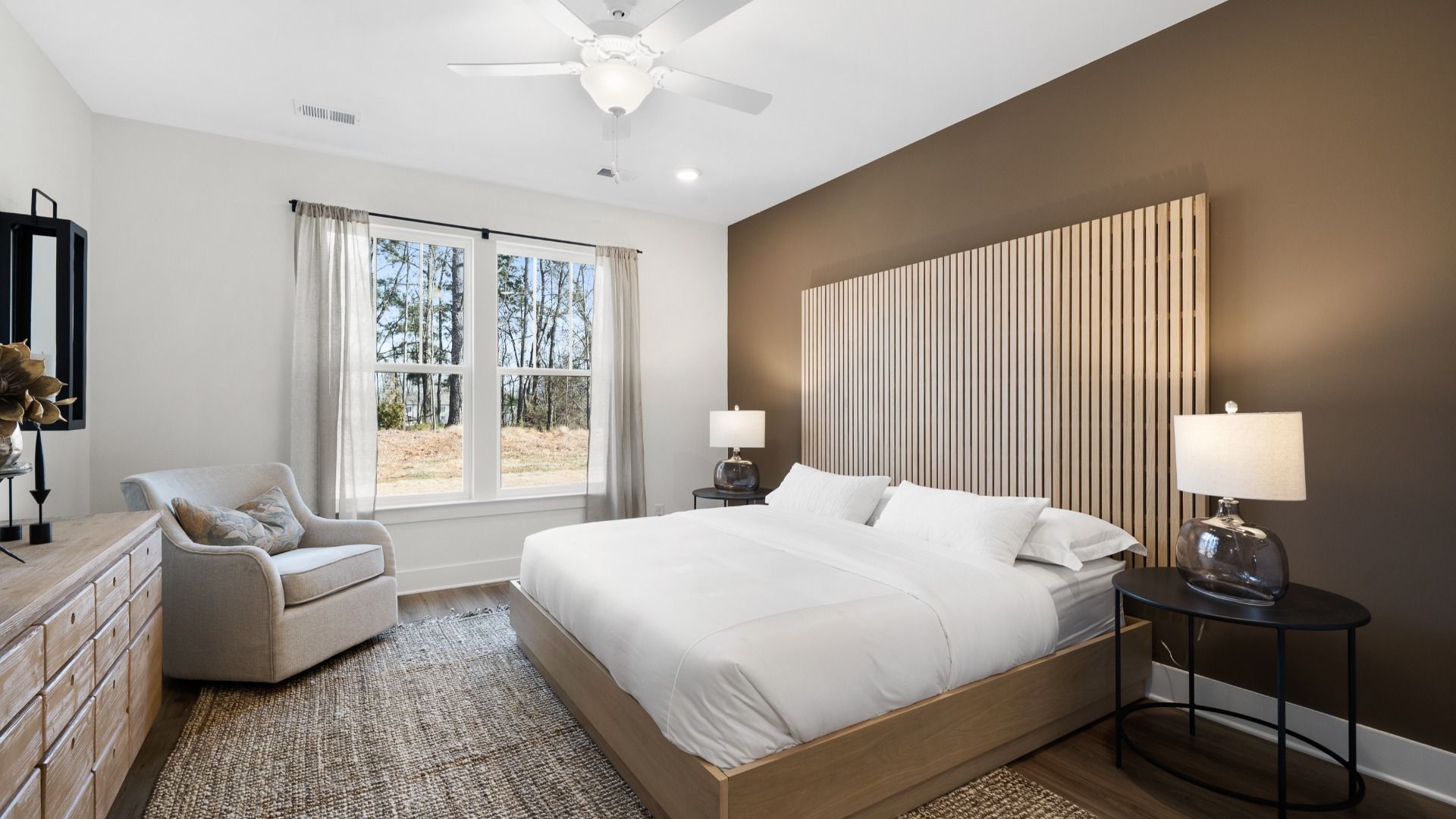 Primary suite featuring a large natural wood slat headboard and dark accent wall at Village at Midway in Anderson, SC