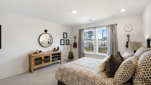 Bedroom at Village at Midway by DRB Homes in Anderson, SC with farmhouse decor, large windows, and plush gray carpeting