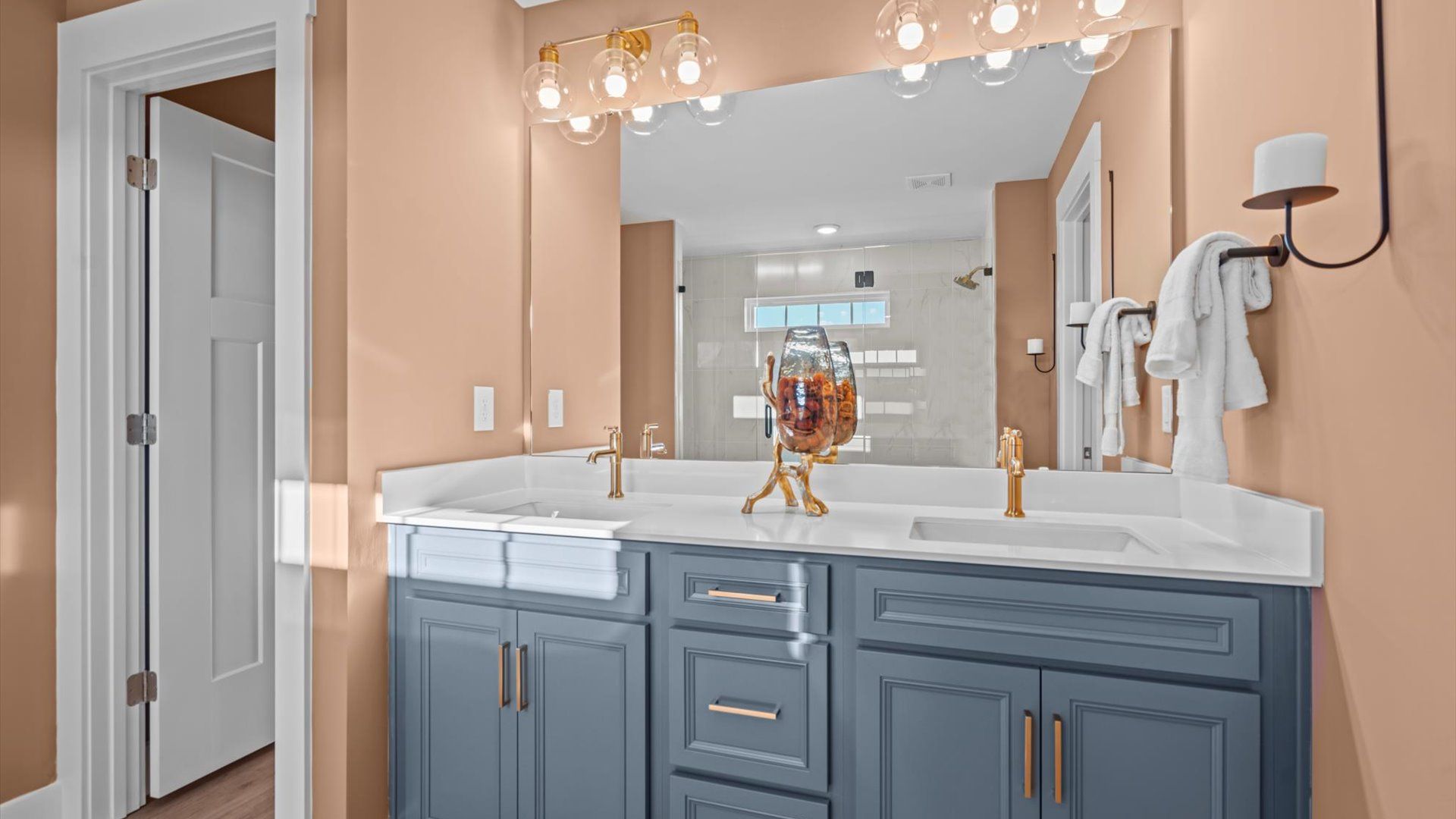 Stunning blue cabinetry with gold accents in primary bath at Mulberry Estates by DRB Homes in Simpsonville, South Carolina