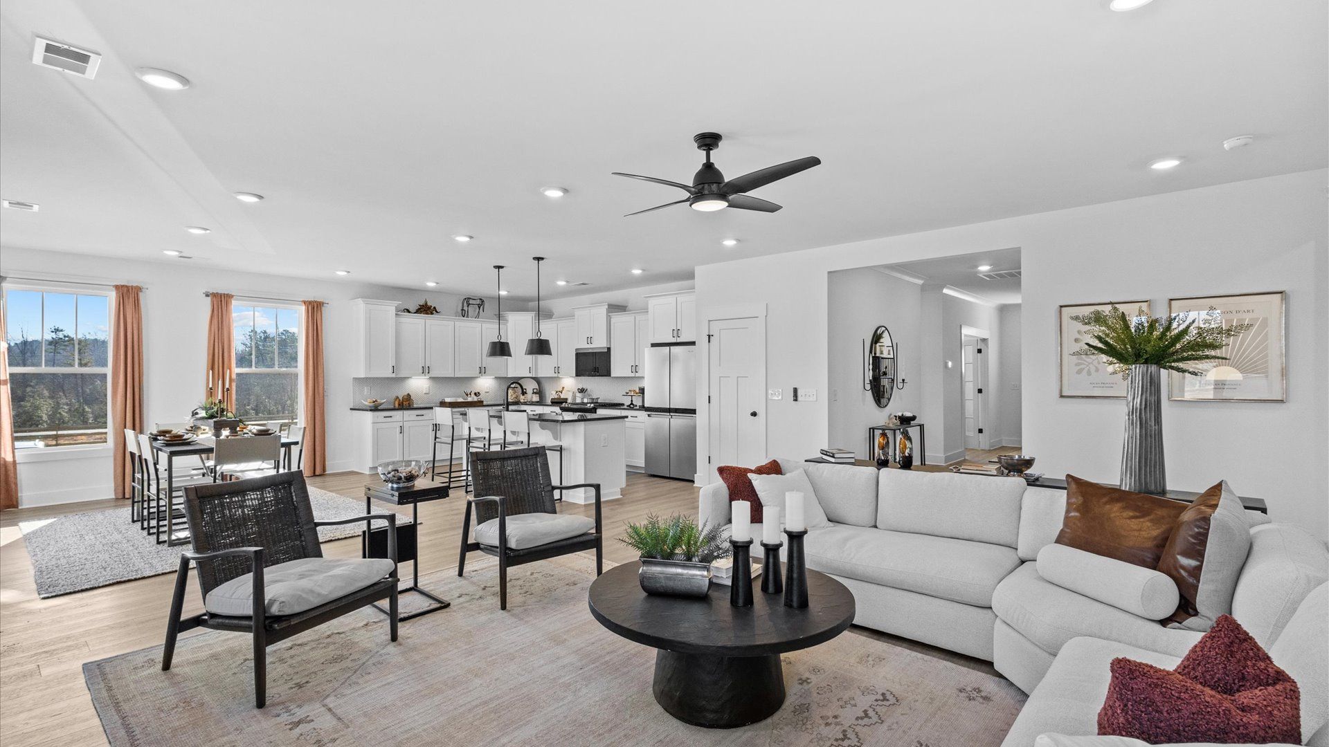 Spacious, modern family room with black accents and hardwood flooring at Wells Crossing by DRB Homes in Seneca, SC