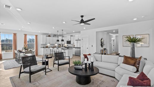 Spacious, modern family room with black accents and hardwood flooring at Wells Crossing by DRB Homes in Seneca, SC