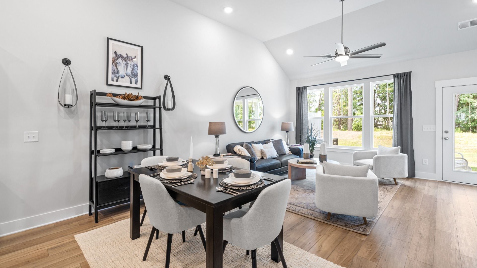 Elevated family room with two story ceilings and ceiling fan with large windows at Aspen Ridge by DRB Homes in Lyman, SC