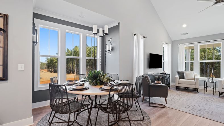 Breakfast area of the Lakehurst floorplan featuring 2 story ceiling, large windows and LVP flooring at Village at Midway