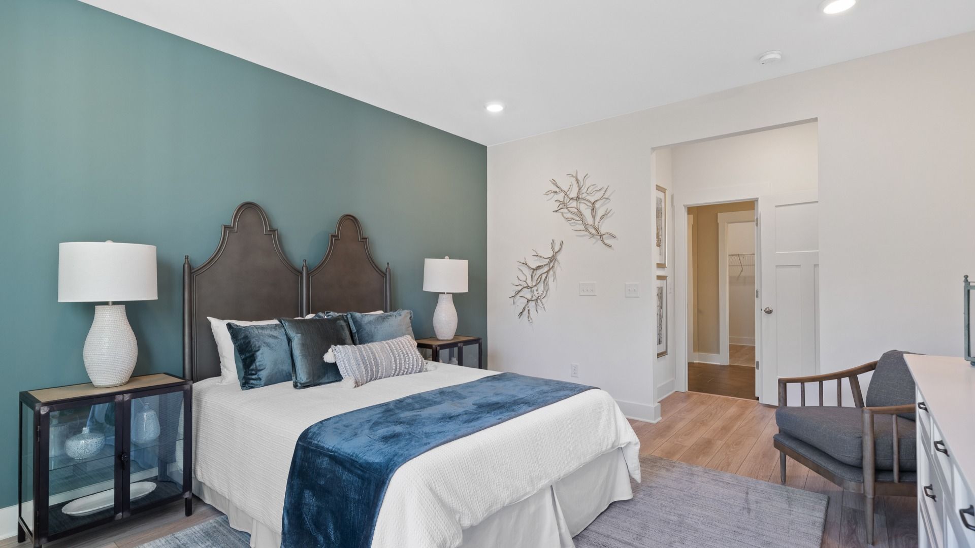 Lakehurst primary suite at Village at Midway with farmhouse decor, dark accent wall, en suite bathroom and LVP by DRB Homes