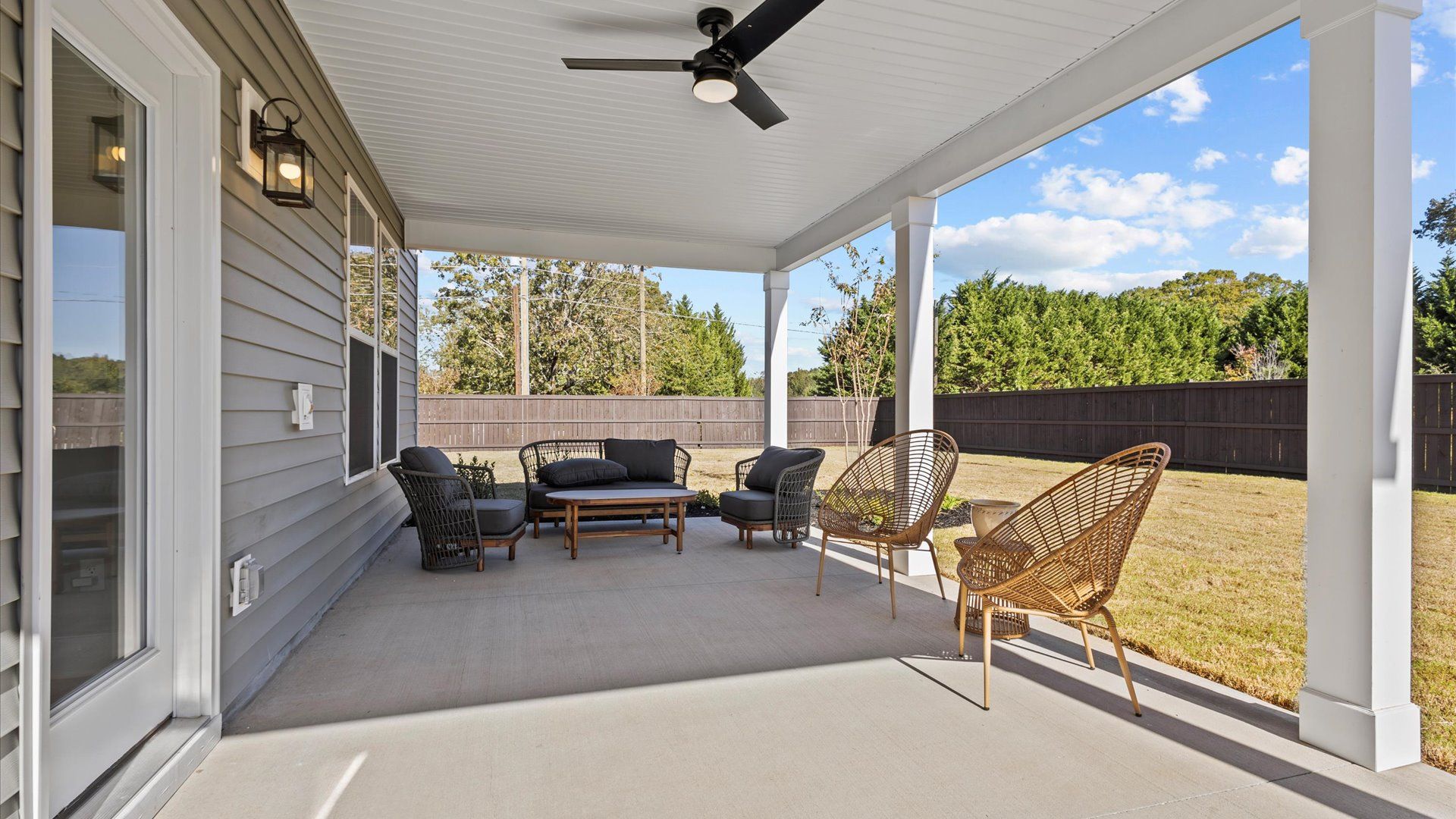 Long, spacious covered back porch with ceiling fan and patio furniture with direct access to backyard at Pleasant Falls