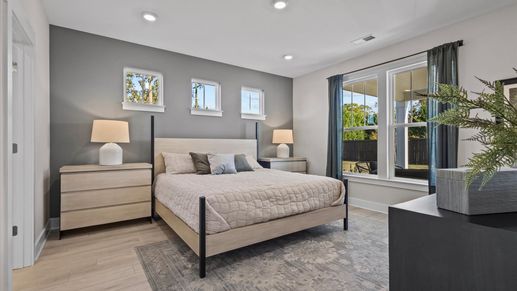 Organically decorated primary suite with large windows and hardwood floors, plus elevated ceilings at Pleasant Falls