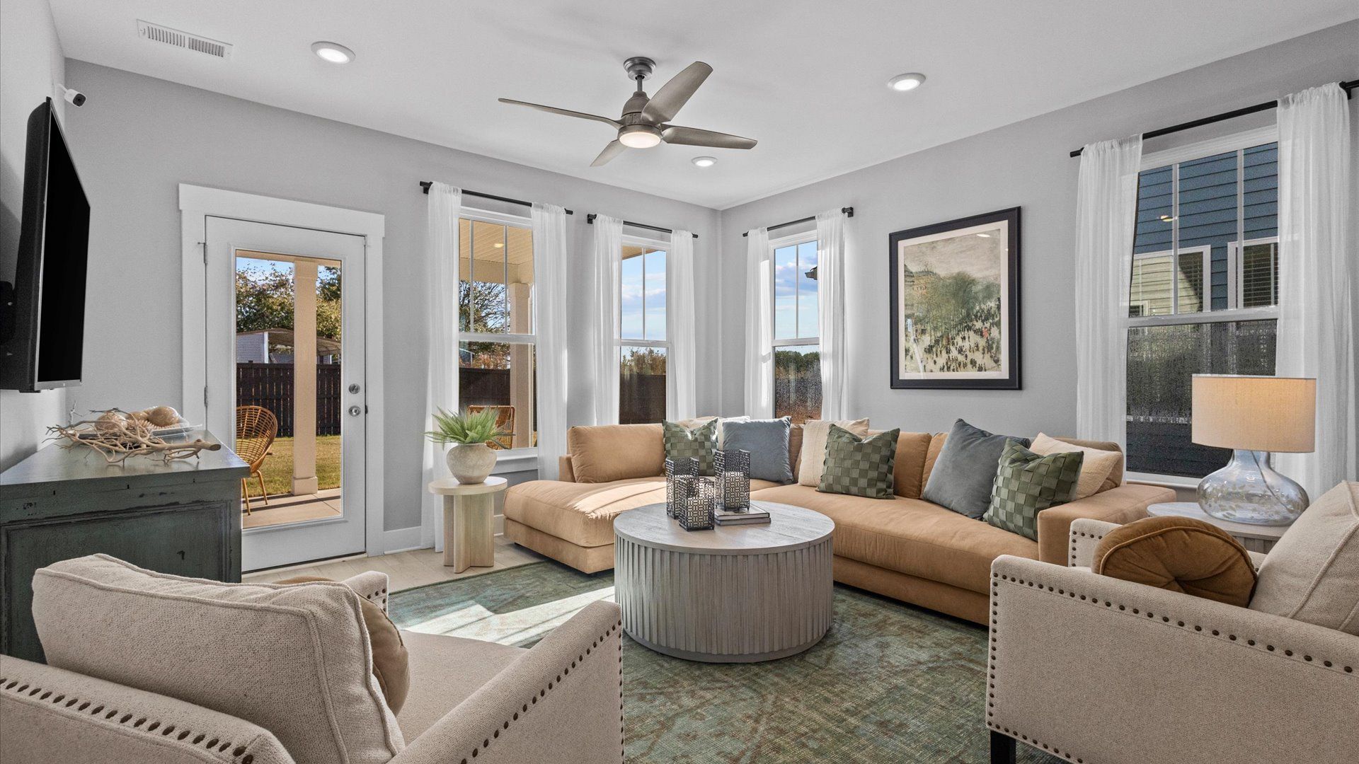 Cozy family room boasting with windows, hardwood flooring, and a ceiling fan at Pleasant Falls by DRB Homes in Moore, SC