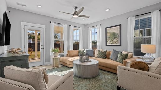 Cozy family room boasting with windows, hardwood flooring, and a ceiling fan at Pleasant Falls by DRB Homes in Moore, SC