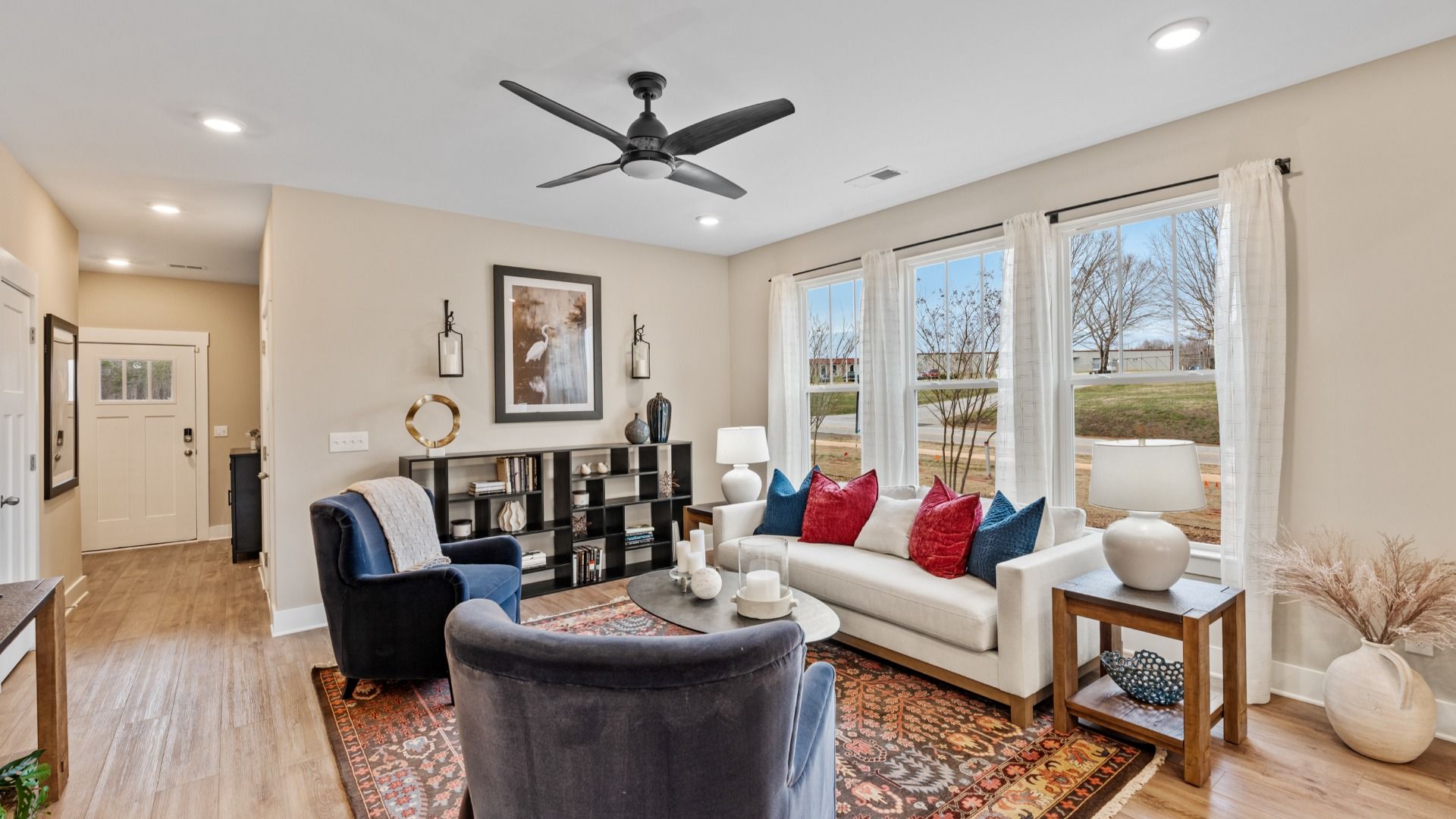 Cozy family room with ceiling fan and large windows in two story townhome at Saluda Crossing by DRB Homes in Piedmont, SC