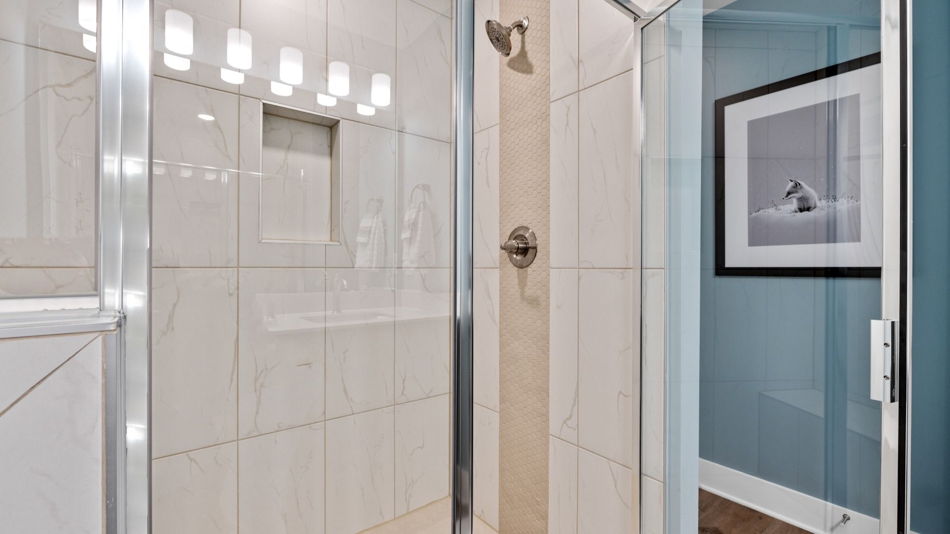 Marble tiled walk-in shower in primary bathroom in two story townhome at Saluda Crossing by DRB Homes in Piedmont, SC