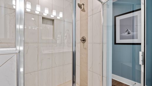 Marble tiled walk-in shower in primary bathroom in two story townhome at Saluda Crossing by DRB Homes in Piedmont, SC