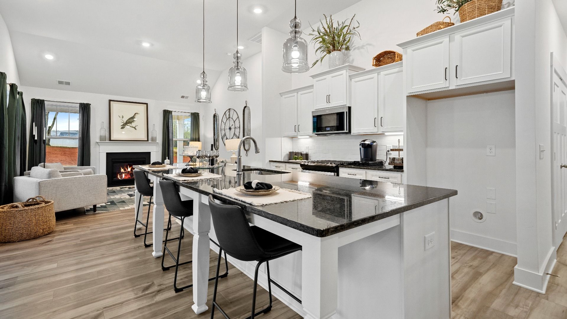 Large kitchen with white cabinetry, black granite countertops & modern appliances at Pinebrook by DRB Homes in Woodruff, SC