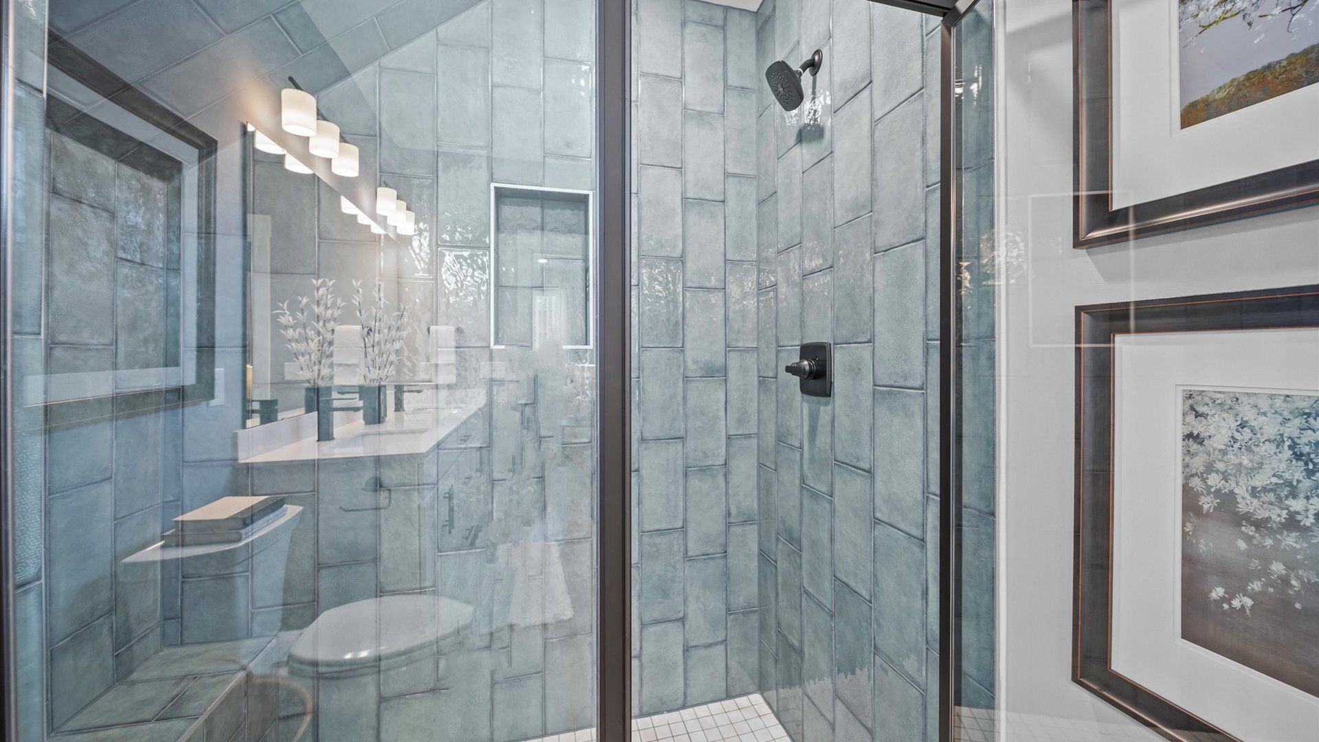 Spacious primary bathroom with white cabinetry, large vanity, and tiled walk-in shower