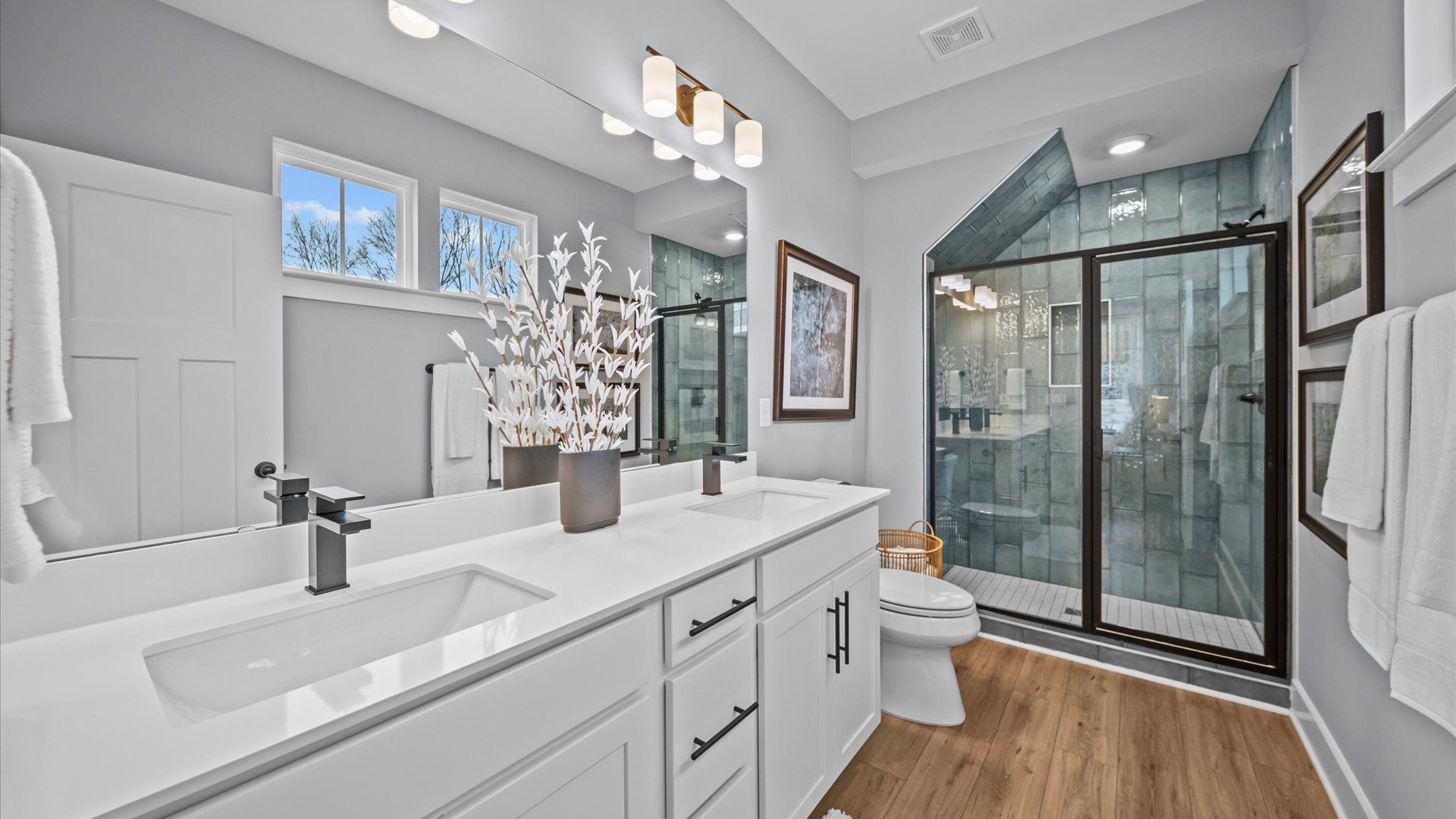 En suite primary bathroom with white cabinets, white countertops, and tiled walk-in shower in Aspen Ridge by DRB Homes