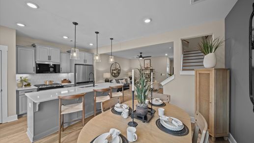 Inviting breakfast area with wood accents adjacent from open concept kitchen with large island with counterstools