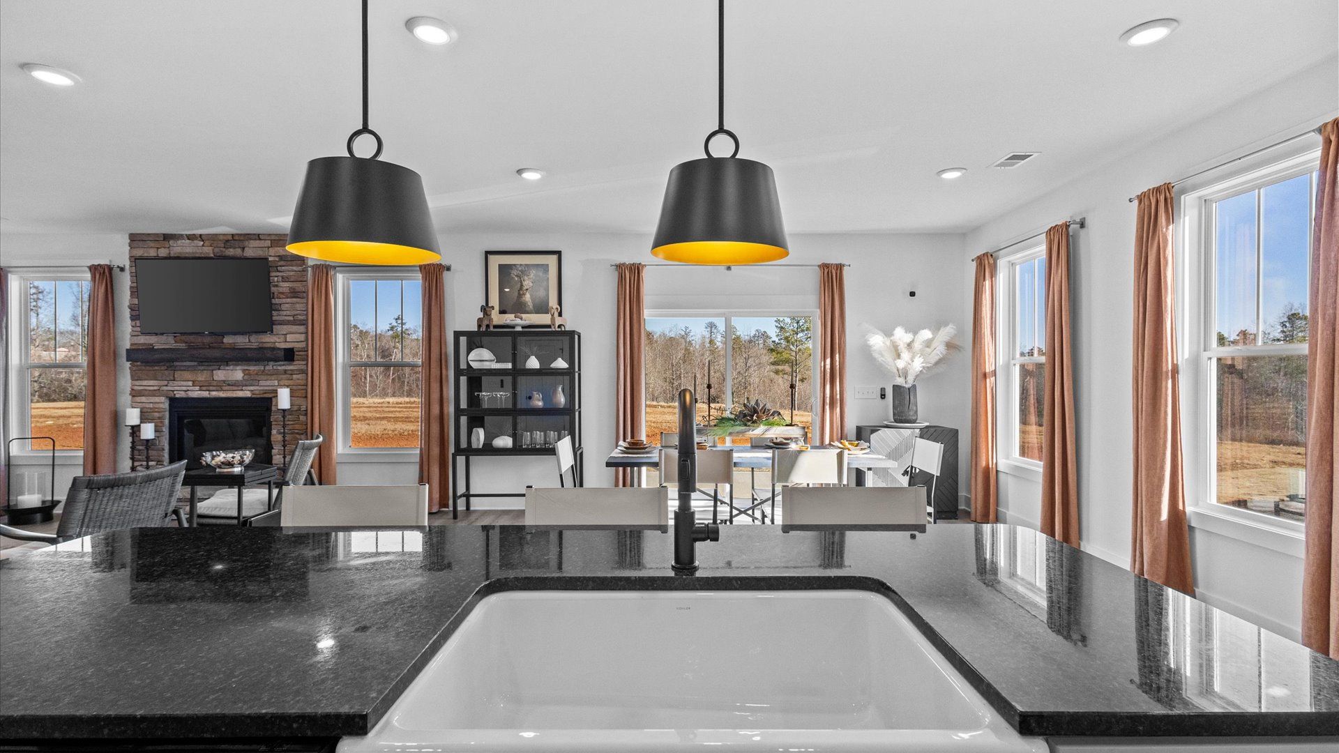 DRB Homes' Wells Crossing kitchen with black granite countertops on large kitchen island with farmhouse sink in Seneca, SC