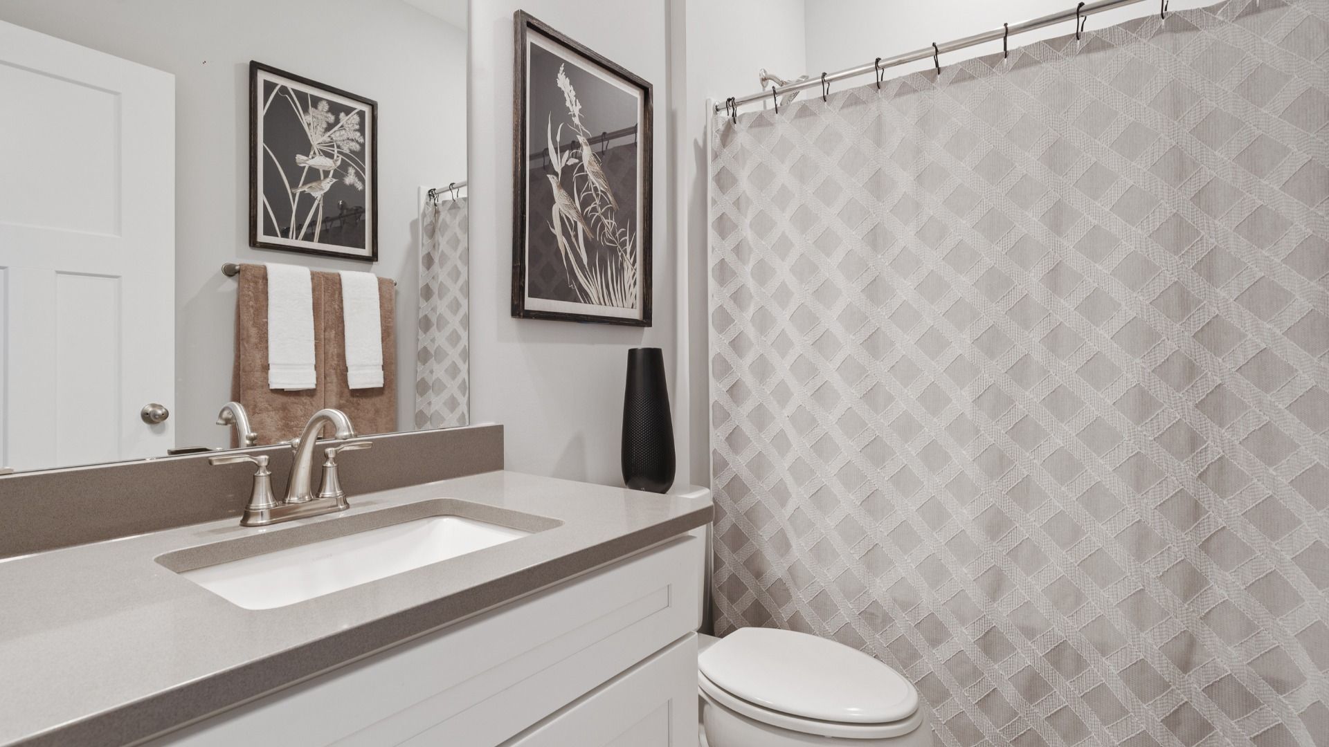 Secondary bathroom with polished nickel accents and colored countertops at Walnut Ridge by DRB Homes in Inman, SC