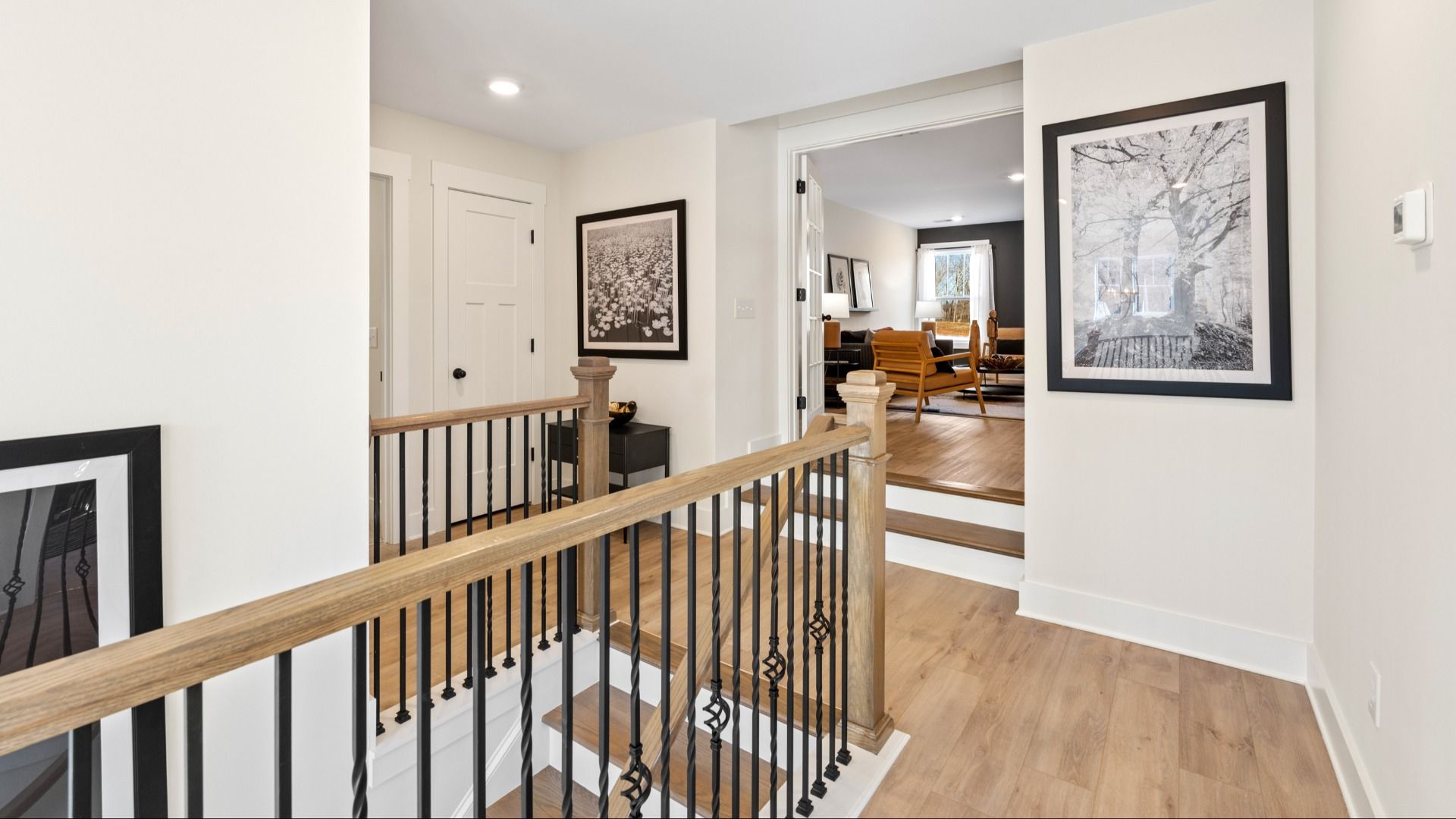 Hardwood flooring at top of stairs landing on second floor with elevated ceilings at Fox Hollow by DRB Homes