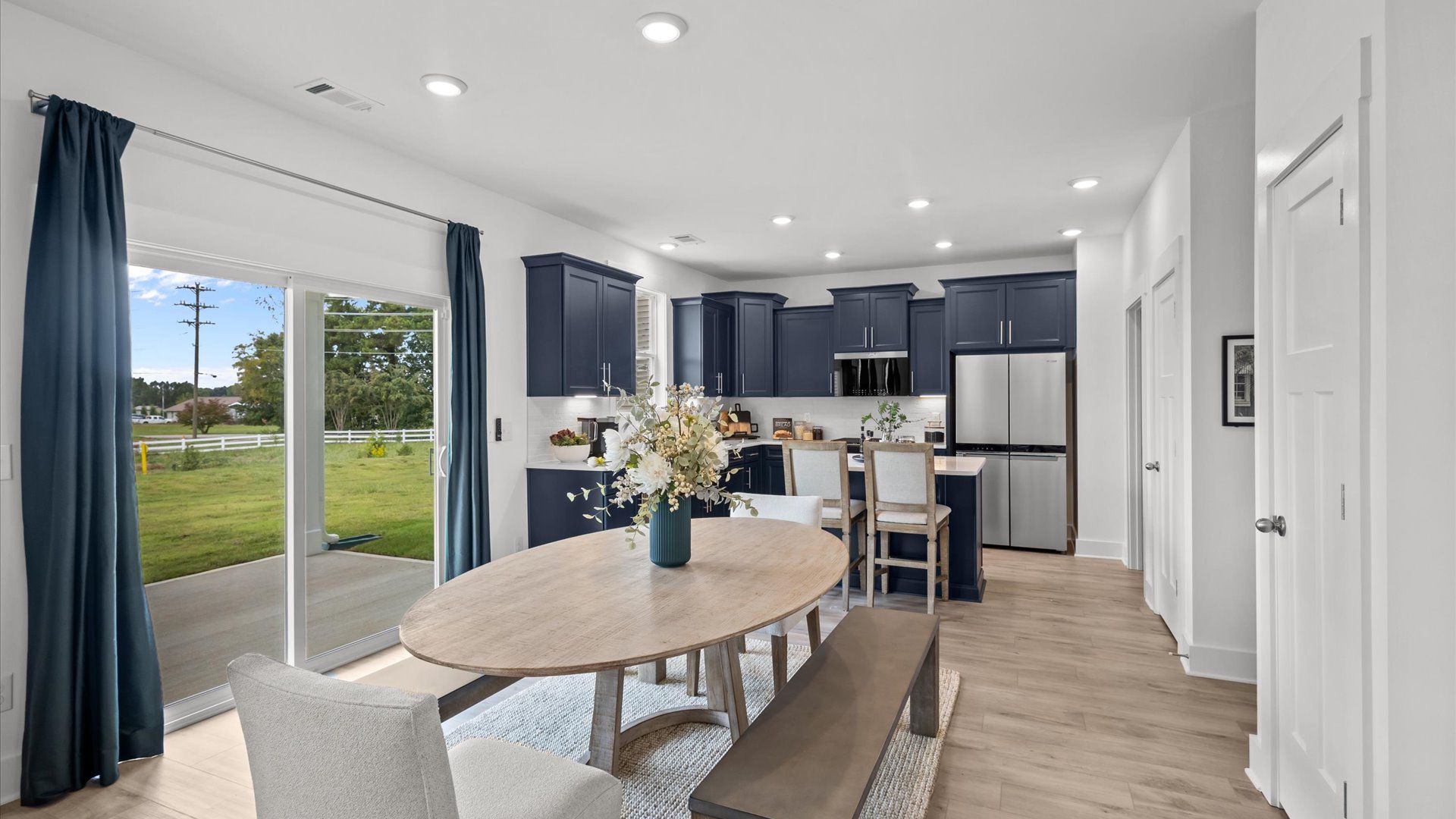 Navy cabinetry kitchen with white quartz countertops and large windows