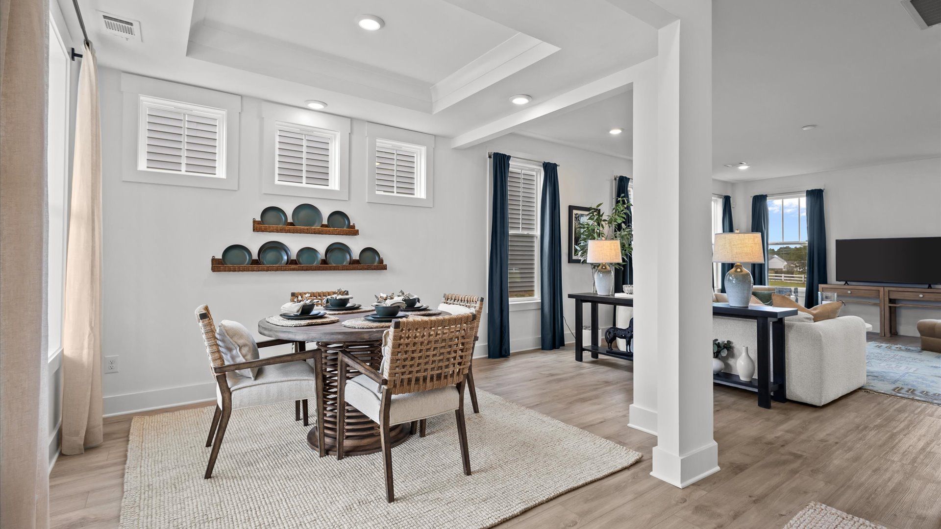 Elevated, vaulted ceiling dining room with large windows and hardwood flooring at Woodglen by DRB Homes