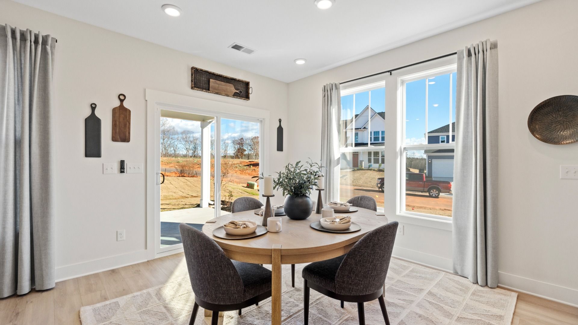 DRB Homes' Woodglen featuring two story home with breakfast area with large windows & hardwood flooring adjacent from kitchen