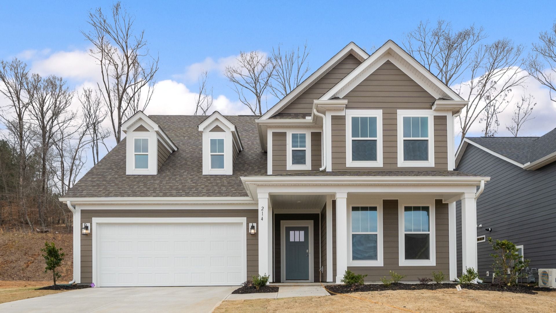 Stunning light gray exterior two story home with two car garage and large windows at Pelham Crossing by DRB Homes