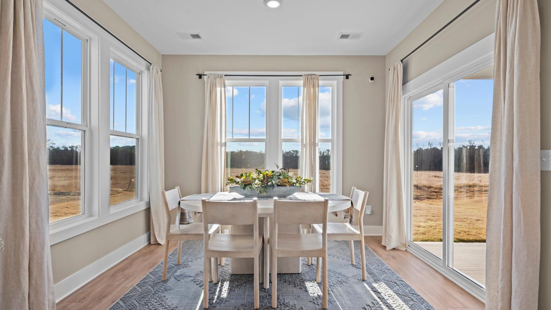 Extended breakfast area with large surrounding windows plus screen door for backyard access at Pelham Crossing by DRB Homes