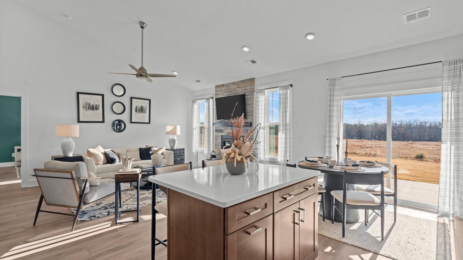 Open concept living spaces with large family room with fireplace and adjacent wood cabinetry kitchen in Greenville, SC