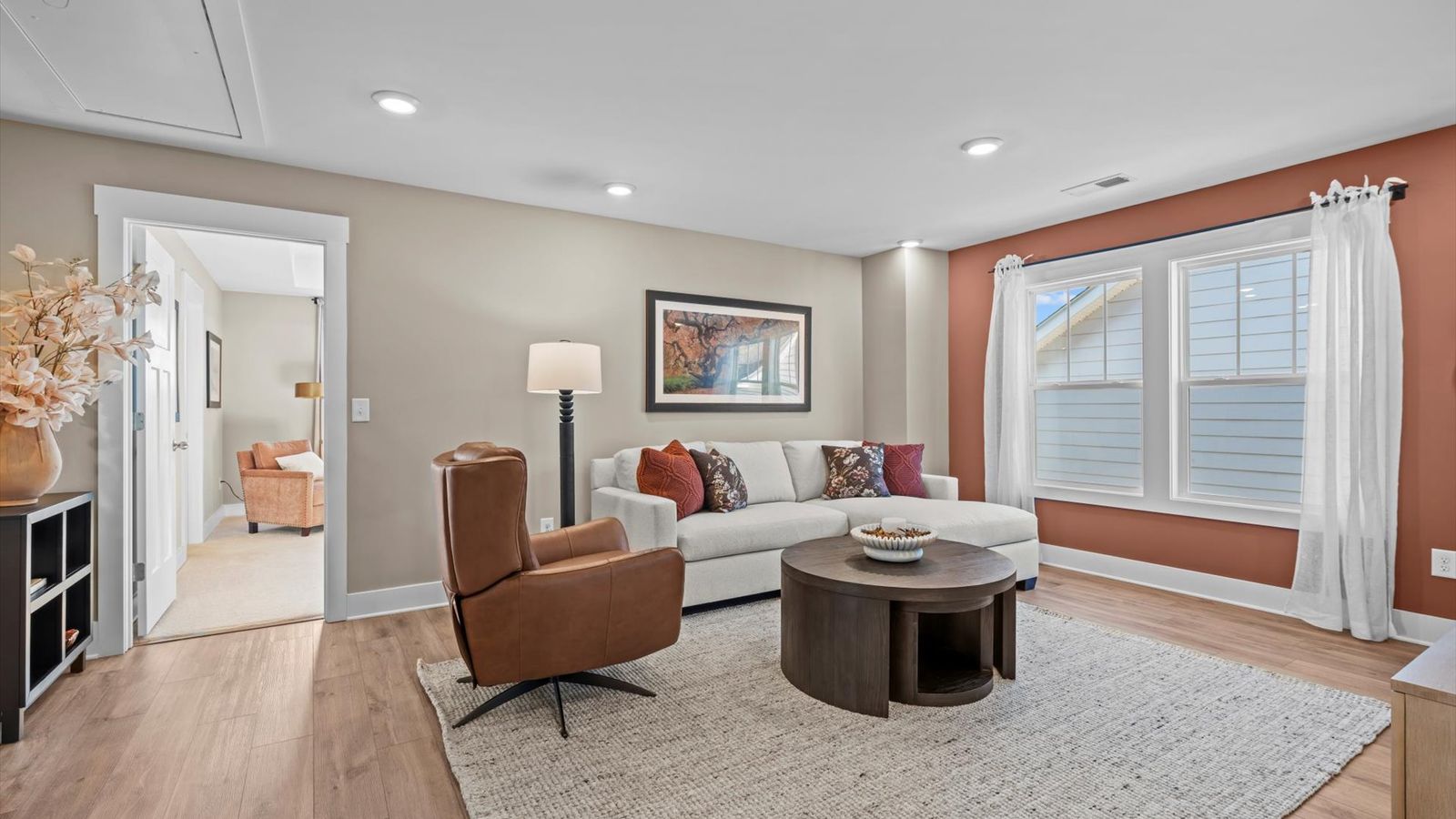 Upstairs loft space with cozy, inviting feel with hardwood flooring and large bay window at Pelham Crossing by DRB Homes