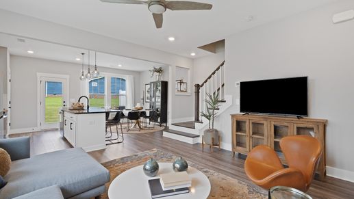Spacious hardwood flooring family room with large windows and ceiling fan at Barton Hollow by DRB Homes in Fountain Inn, SC