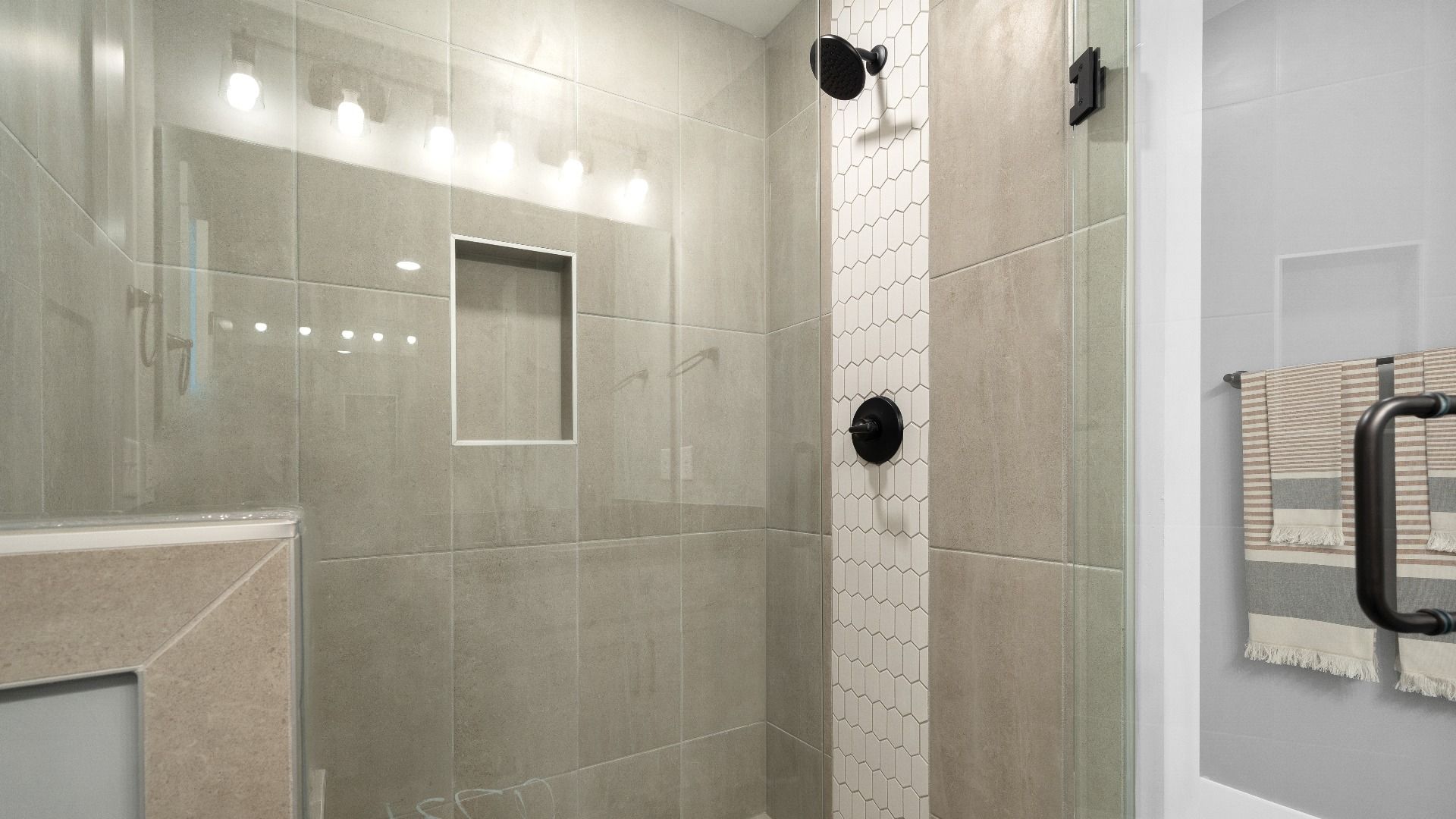 Frameless tiled walk-in shower in luxe en suite primary bathroom at Barton Hollow by DRB Homes in Fountain Inn, SC
