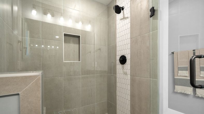 Frameless tiled walk-in shower in luxe en suite primary bathroom at Barton Hollow by DRB Homes in Fountain Inn, SC